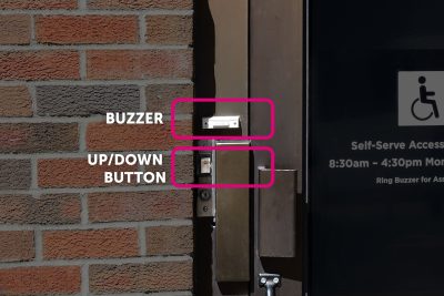 Door Buzzer Updown Button Brick Wall Next Door Door buzzer and up/down button on a brick wall next to a door with accessibility information.