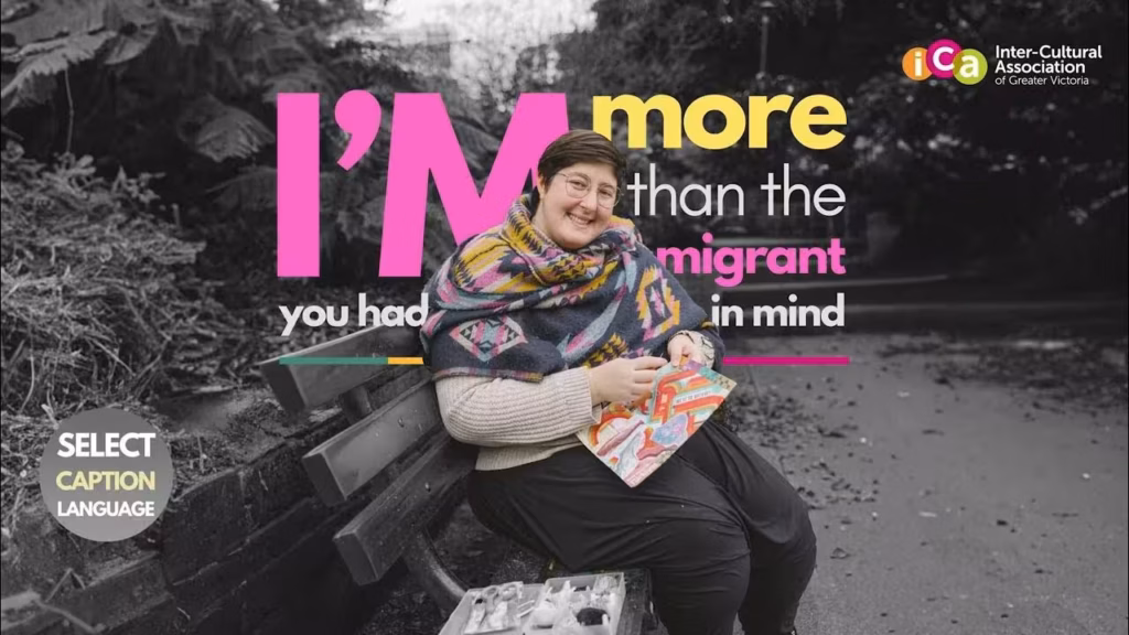 A person smiles while sitting on a bench holding a colorful booklet. Text reads, "I'm more than the migrant you had in mind.