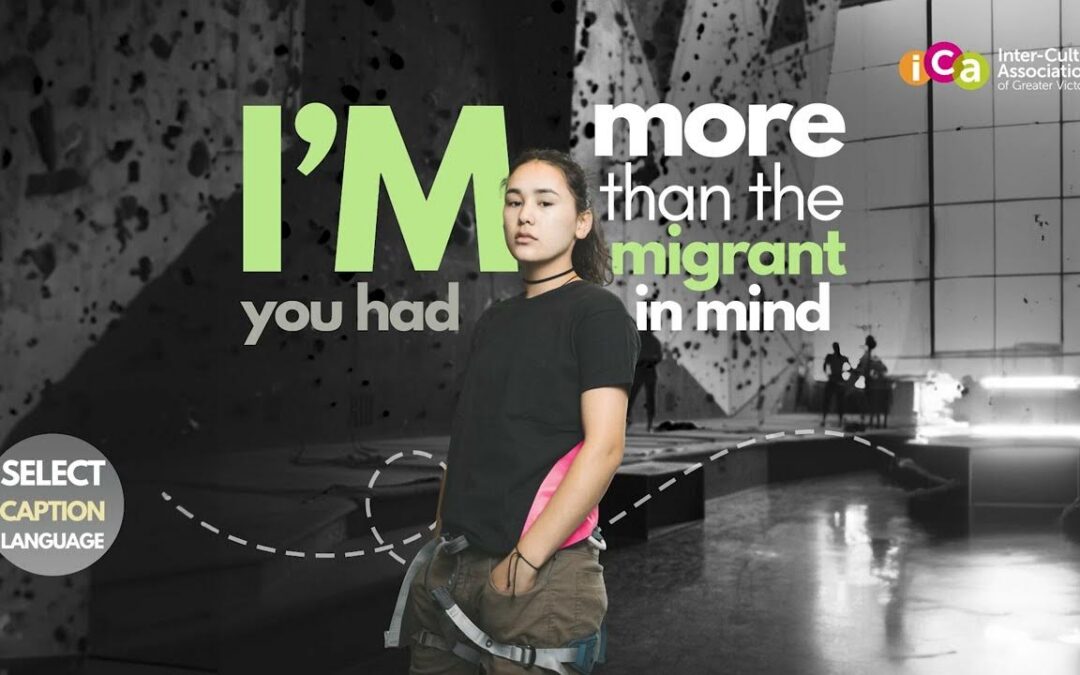 A young woman stands in front of text that reads "I'M more than the migrant in mind".