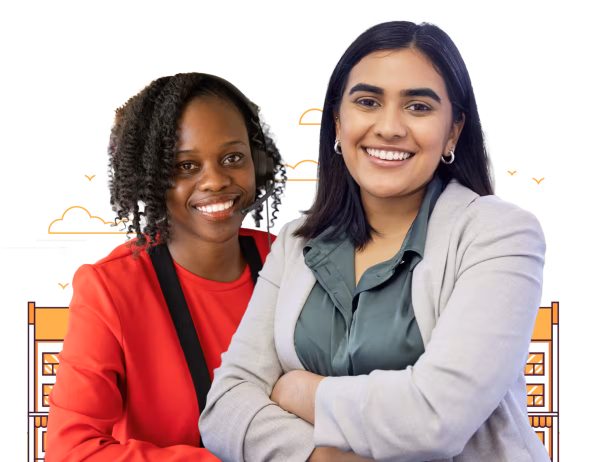 Two women, one wearing a red shirt and headset, the other a light suit, smile at the camera.